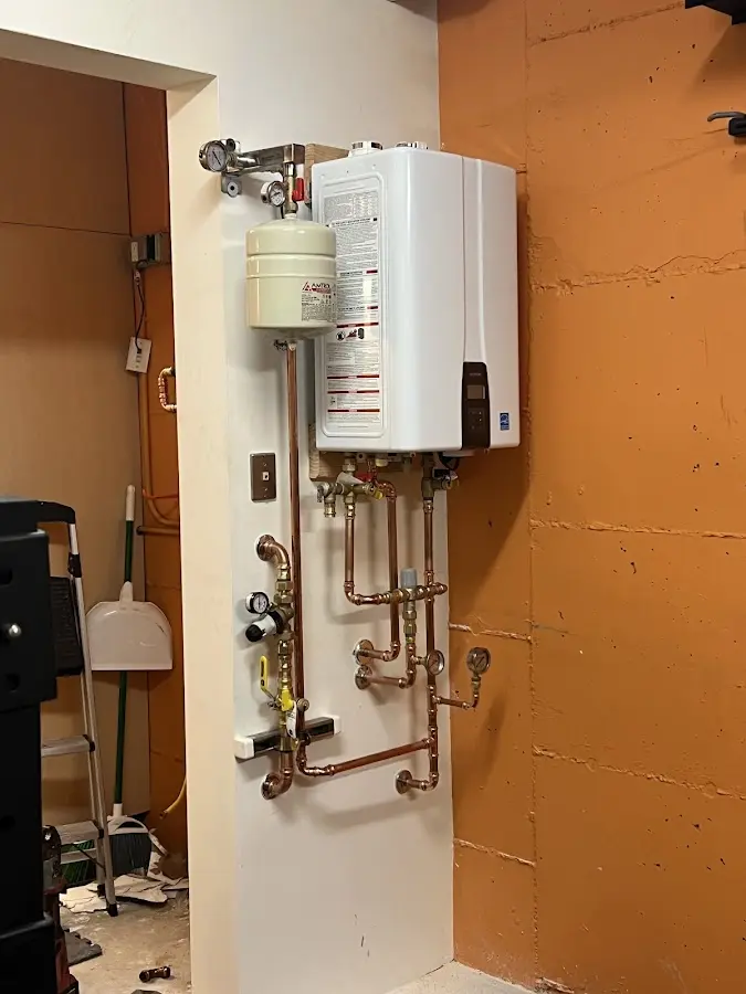 Plumbing technician inspecting water heater connections in Gloucester